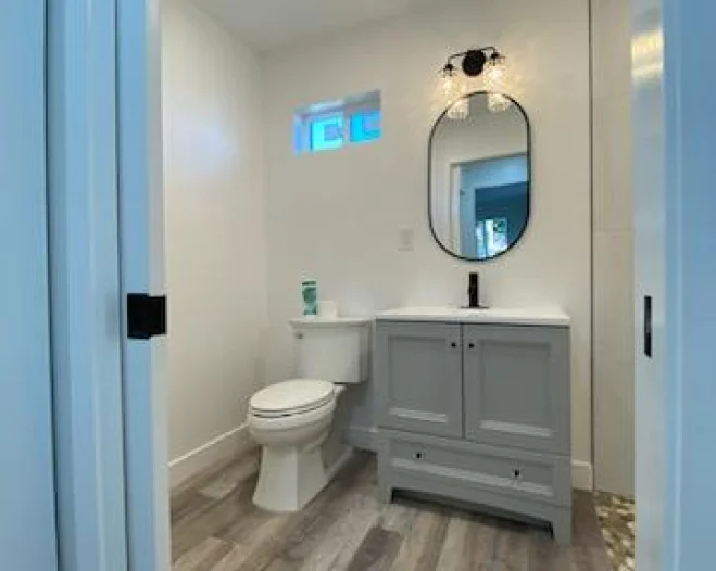 light grey bathroom with a grey wooden floor